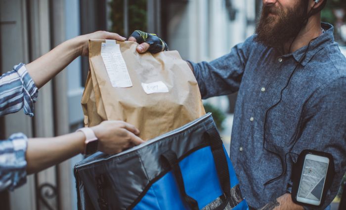 man handing woman a food delivery