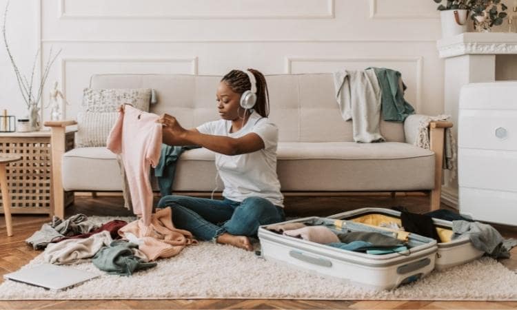 woman folding laundry while listening to a podcast