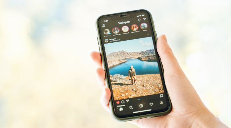 Hand holding phone with Instagram displayed