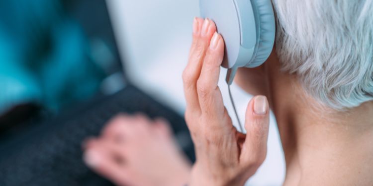 Woman listening to headphones to provide transcription services