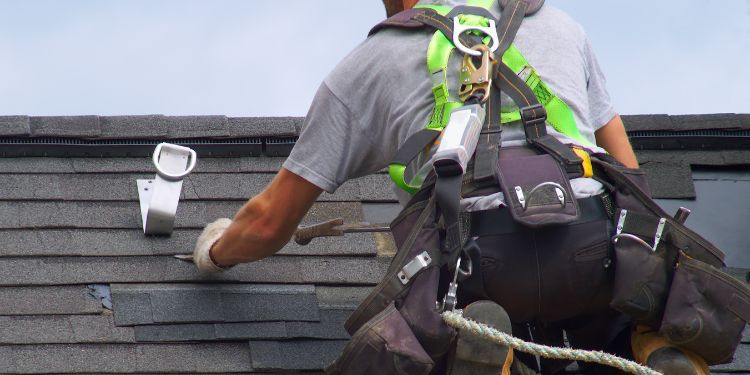 man on a roof working as a roofer