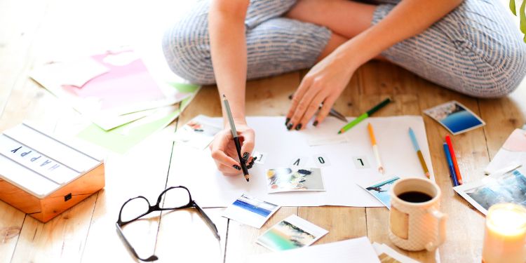 woman creating a vision board on the floor