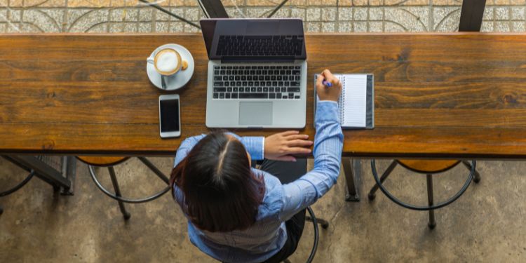 woman writing and working in a coffee shop