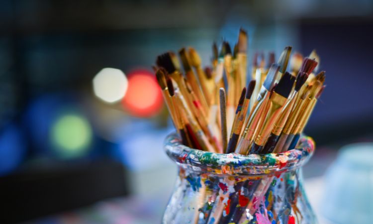 paintbrushes in a colorful jar