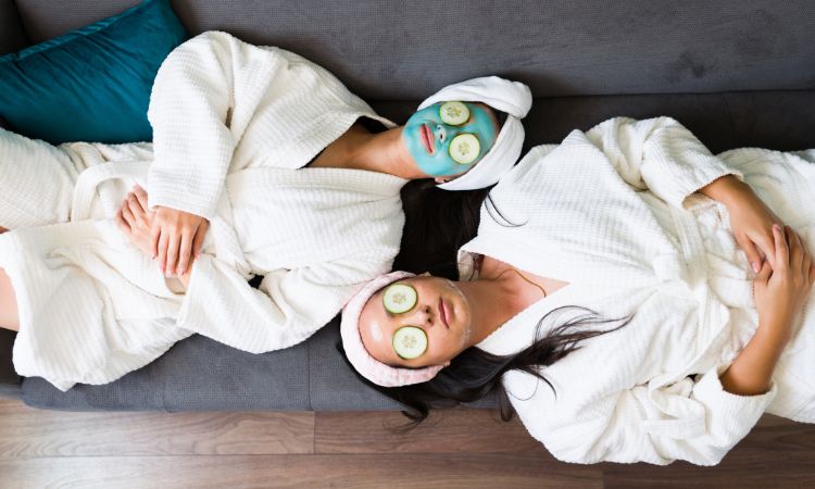 best friends looking funny with cucumbers on their eyes in bathrobes